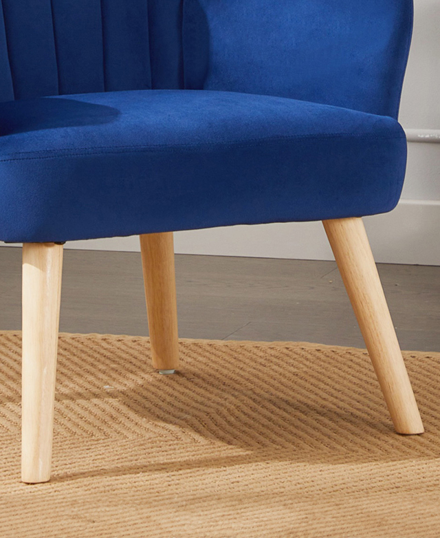 Tapered, modern-style rubberwood legs are gently splayed beneath the blue armchair. They're on a tan rug. Tapered, modern-style rubberwood legs are gently splayed beneath the blue armchair. They're on a tan rug.