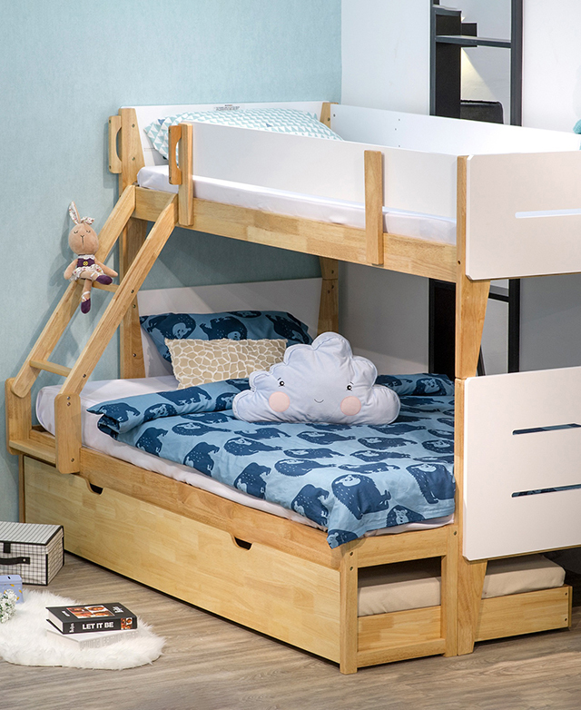 A single-over-double bed arrangement features blue patterned bedding and cute cushions in a blue and white room.