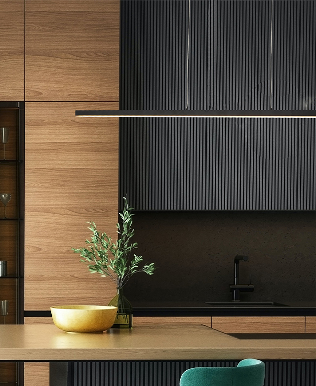 The bar pendant light is hung over a timber kitchen island that is decorated with gum leaves and a bowl.