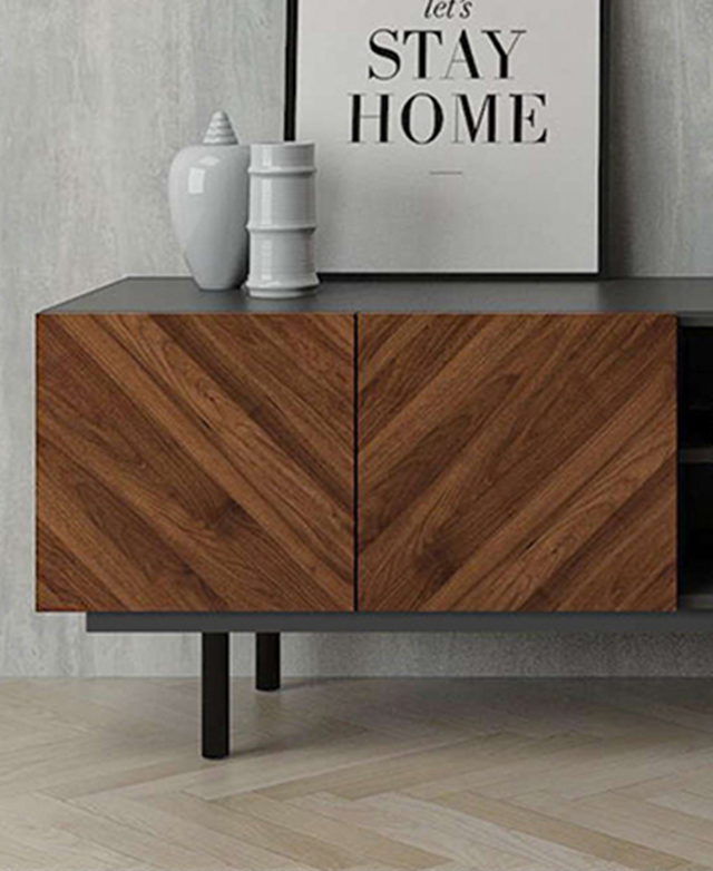 Cupboard doors of the TV unit have a rich brown colour. The top of the unit is styled with ceramics and typographic art. Cupboard doors of the TV unit have a rich brown colour. The top of the unit is styled with ceramics and typographic art.