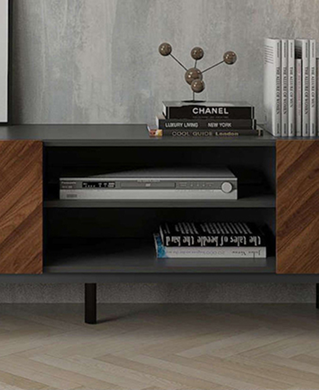 The two central open shelves hold a silver sound system and a stack of books. The two central open shelves hold a silver sound system and a stack of books.
