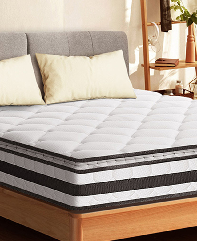 Black and white mattress is on a timber bed frame, with two neutral pillows on top. Black and white mattress is on a timber bed frame, with two neutral pillows on top.