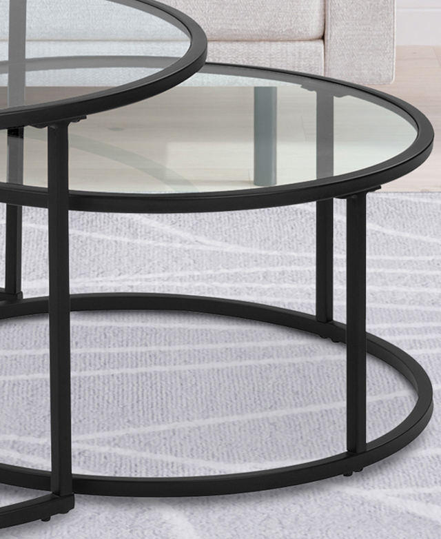 The round, black metal coffee tables have open bases and a simple structure. They're nesting on a grey rug.