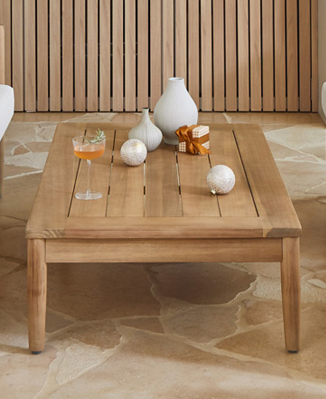 Full coffee table is topped with a cocktail, baubles, a gift, and ceramics. It's on a peachy tiled ground. Full coffee table is topped with a cocktail, baubles, a gift, and ceramics. It's on a peachy tiled ground.