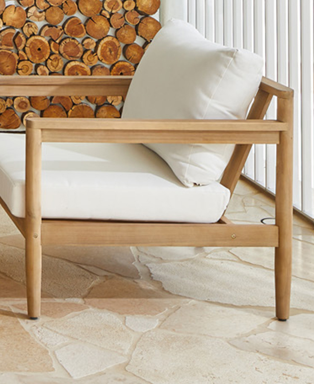 Side view of an armchair shows its slender frame and thick white cushions. It's on peachy tiles. Side view of an armchair shows its slender frame and thick white cushions. It's on peachy tiles.