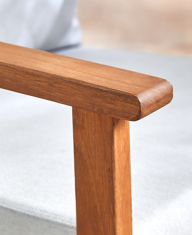A wooden armrest has a rounded end and a rich, medium-brown tone. A wooden armrest has a rounded end and a rich, medium-brown tone.