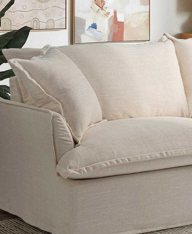 One end of the cream sofa displays the thick cushions, the linen-like texture, and the French seams. One end of the cream sofa displays the thick cushions, the linen-like texture, and the French seams.