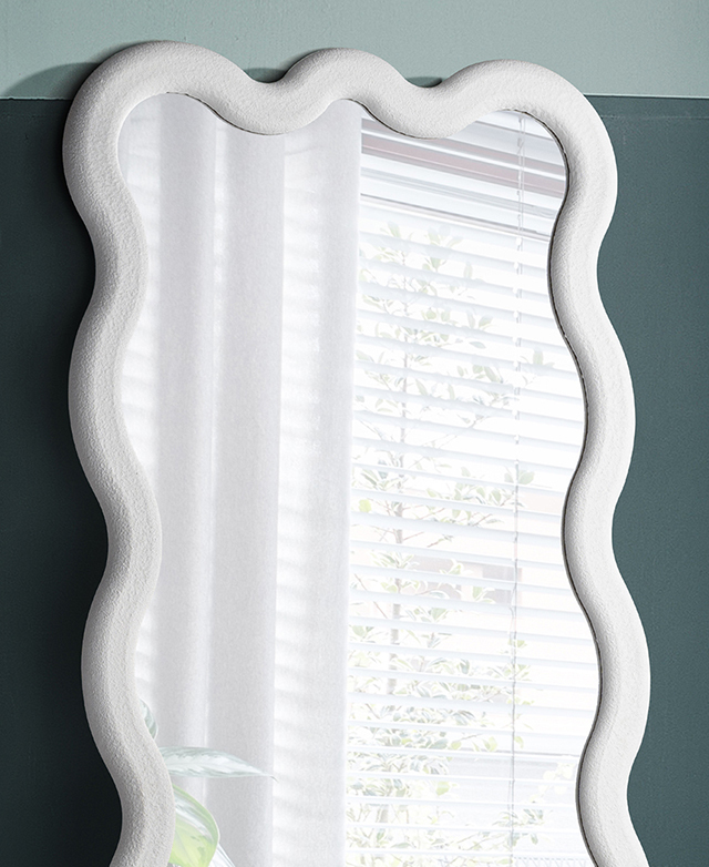 Close up of the top of the mirror shows the white, wavy frame's textured finish. Close up of the top of the mirror shows the white, wavy frame's textured finish.