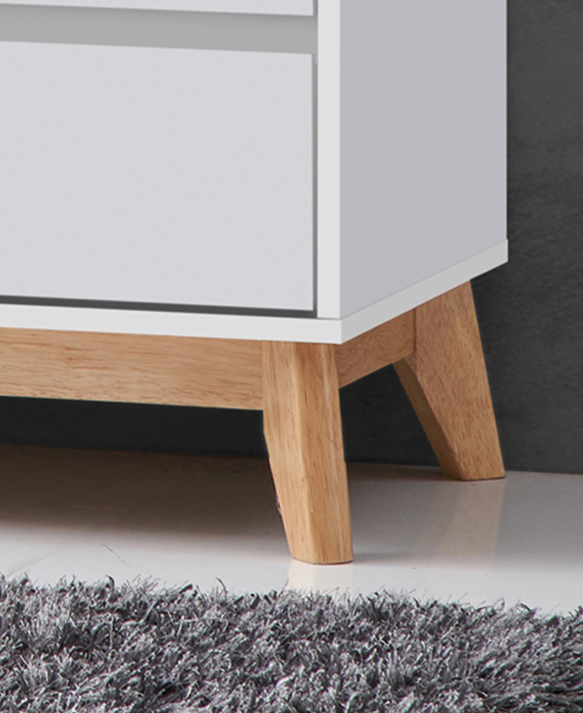 Close up of the chest's rubberwood legs on a polished white floor.