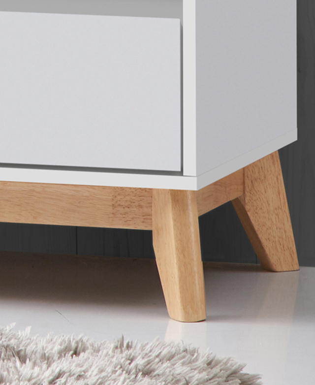 Close up of the chest's rubberwood legs on a polished white floor. Close up of the chest's rubberwood legs on a polished white floor.