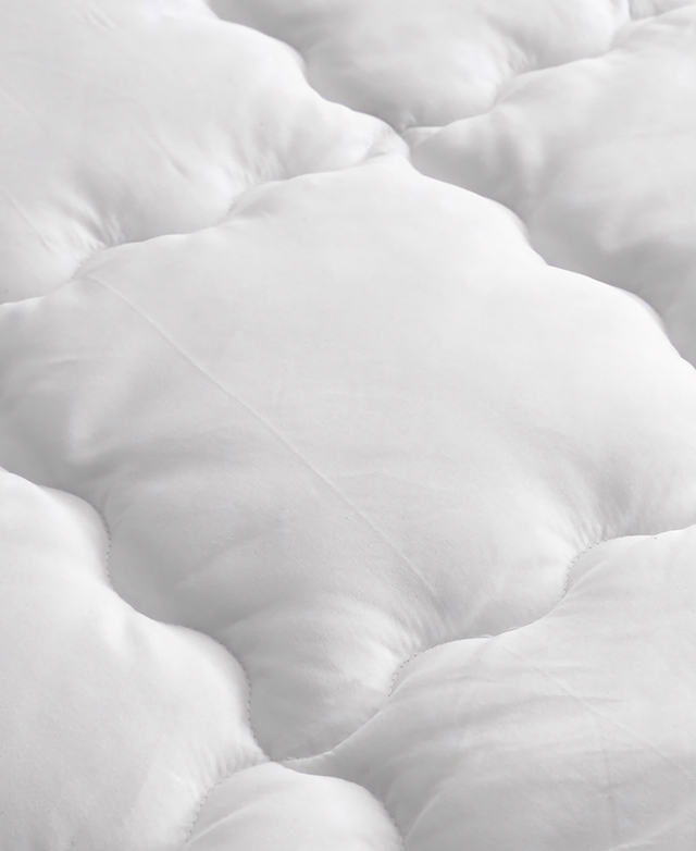 Wavy baffle box stitching is zoomed in on to show the texture of the fill within.