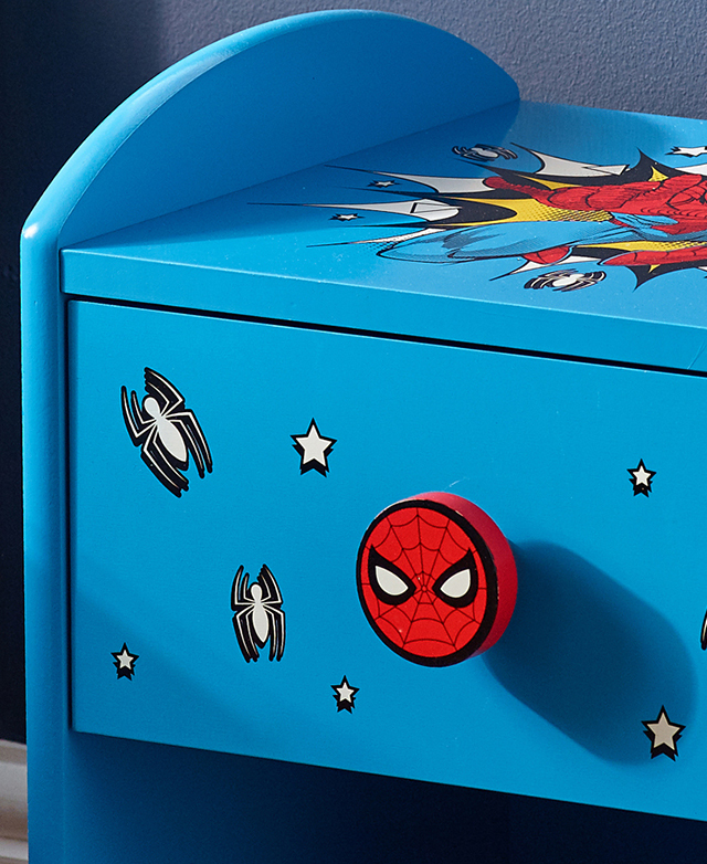 The red Spiderman-covered drawer knob stands out against the bright blue side table body, which is adorned with comic motifs. The red Spiderman-covered drawer knob stands out against the bright blue side table body, which is adorned with comic motifs.
