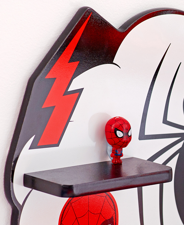 Close view of one end of the Spiderman wall shelf, which has comic motifs and a glossy lacquered finish. Close view of one end of the Spiderman wall shelf, which has comic motifs and a glossy lacquered finish.