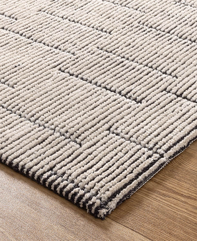 Cropped view of the tufted grid-like pattern highlights the monochrome construction and its texture. Cropped view of the tufted grid-like pattern highlights the monochrome construction and its texture.