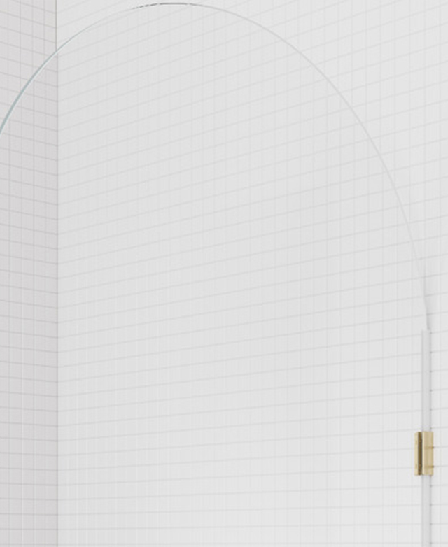 Soft radial curve at the top of the glass shower screen with a tiled bathroom background. Soft radial curve at the top of the glass shower screen with a tiled bathroom background.