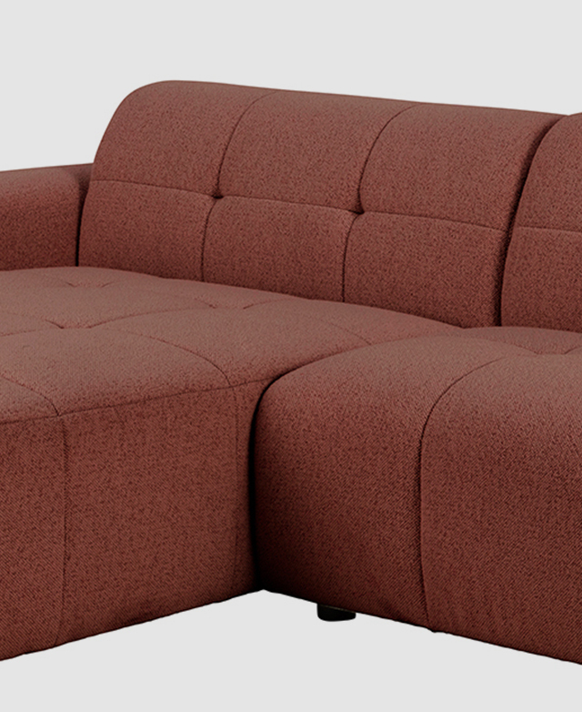 A three-quarter angle shows the blush sofa's depth.