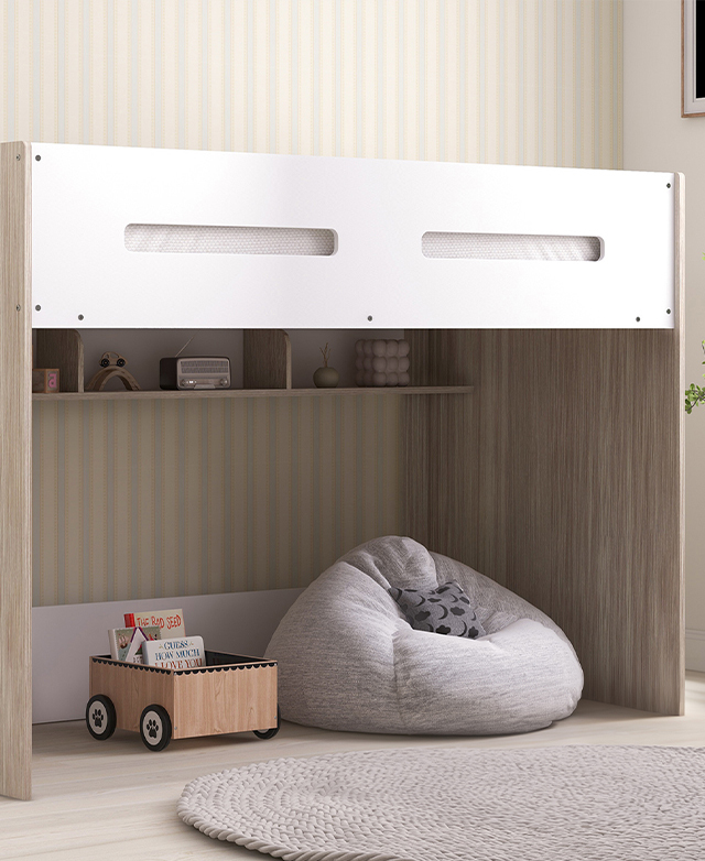 The fully assembled loft bed is against a pastel stripey wall, with a round rug next to it and a beanbag and decor beneath.