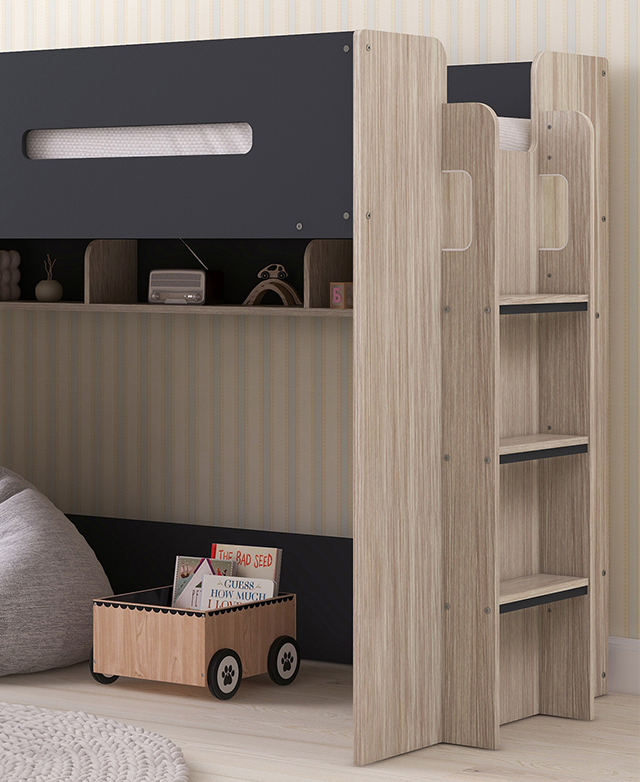 Cropped view of a fully assembled charcoal loft bed against a pastel stripey wall, with decor beneath it.