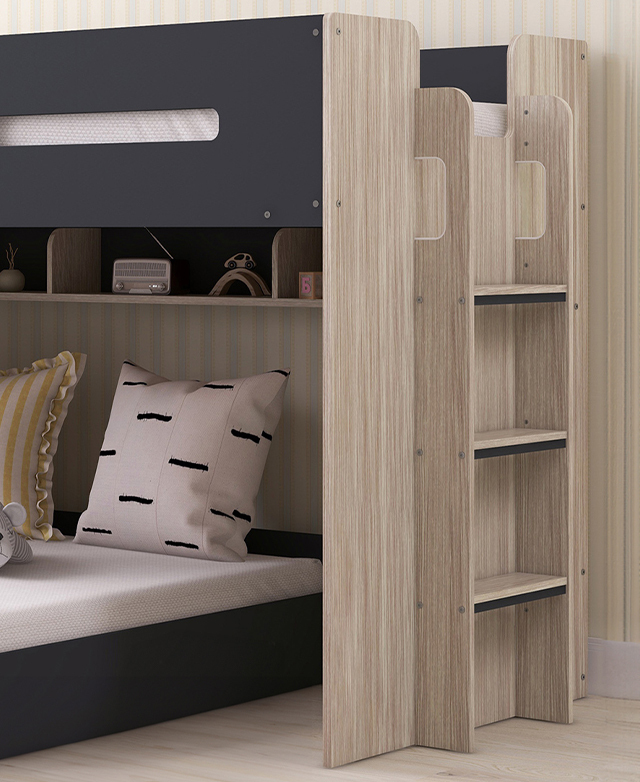 Cropped view of a fully assembled charcoal loft bed against a pastel stripey wall, with cushions on the bottom bunk.