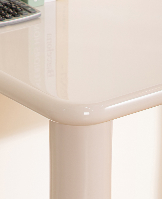 The smooth, glossy writing desk is reflecting books on its surface.