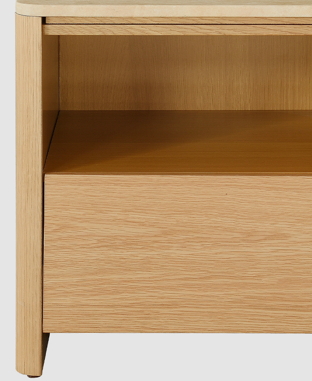The front-facing view of the side table highlights the clean lines, open shelf and handle-free bottom drawer.