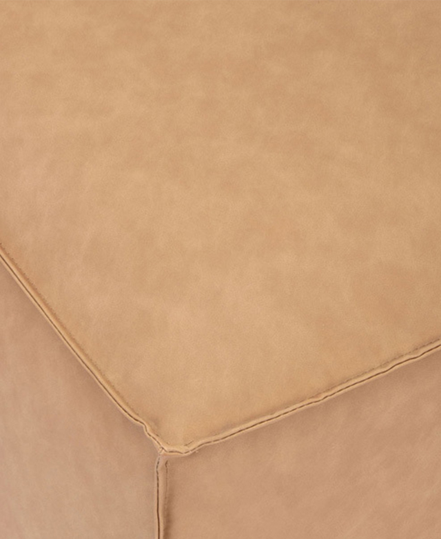 Top-down view of the faux leather ottoman zooms in on the tailored piping trims. Top-down view of the faux leather ottoman zooms in on the tailored piping trims.
