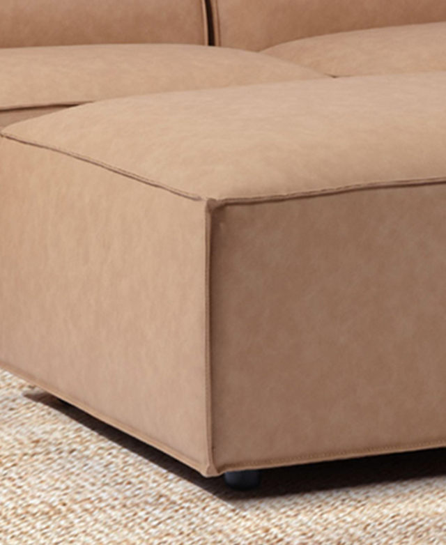Side view of the faux leather ottoman zooms in on the tailored piping trims. Side view of the faux leather ottoman zooms in on the tailored piping trims.