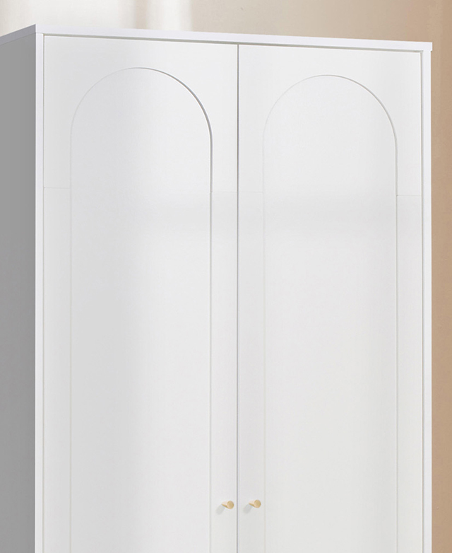 The slightly recessed arches on the front of the white cupboard's doors are in focus. The slightly recessed arches on the front of the white cupboard's doors are in focus.