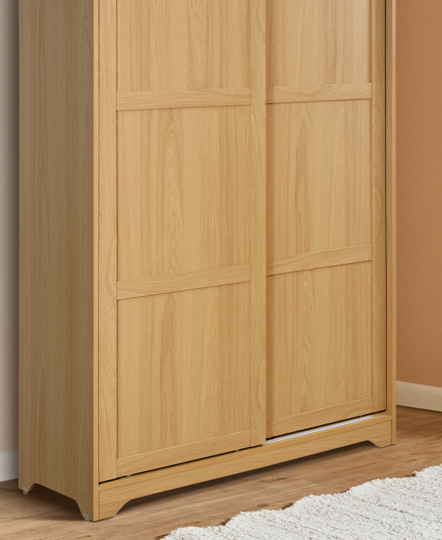 Oak-coloured panelled cupboard doors are slid shut. Oak-coloured panelled cupboard doors are slid shut.