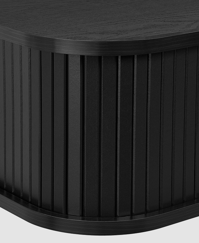 Close view of the black TV unit draws attention to the deep rounded front corners and fluted body.