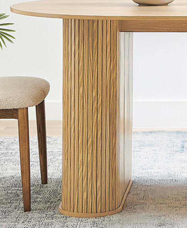 The dining table is on a blue-toned rug, while the focus is on the thick pillar leg which has a fluted finish. The dining table is on a blue-toned rug, while the focus is on the thick pillar leg which has a fluted finish.