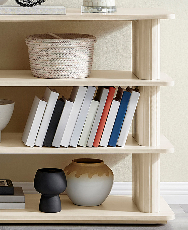 Books and decor adorn the shelves of the cream bookcase. Books and decor adorn the shelves of the cream bookcase.