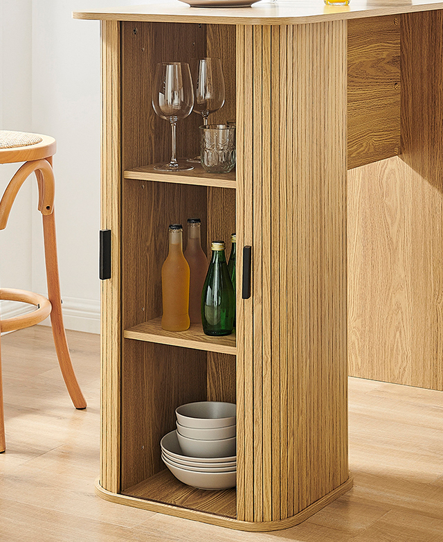 The pillar leg is shown with its fluted sliding doors open, revealing shelves filled with glassware, drinks, and crockery.