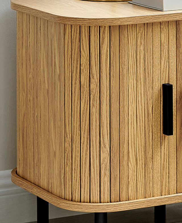 The body of the side table features vertical fluting and a bar-shaped black handle. The body of the side table features vertical fluting and a bar-shaped black handle.