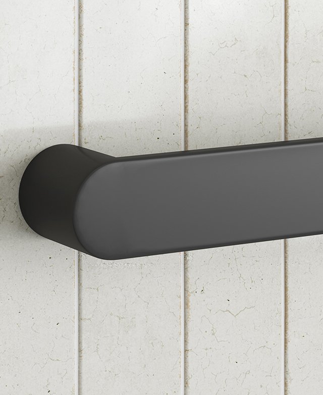 Matte black oval-profile towel rail end cap on white tiled wall.