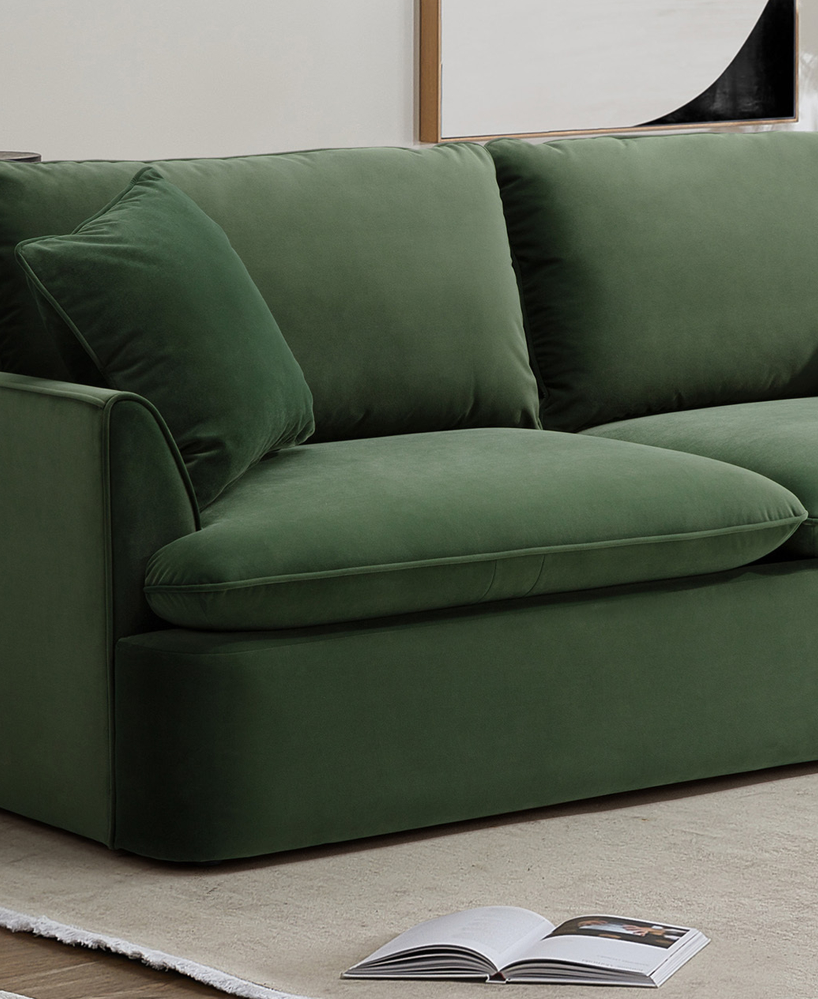 The green velvet sofa is shown at an angle on a beige rug.