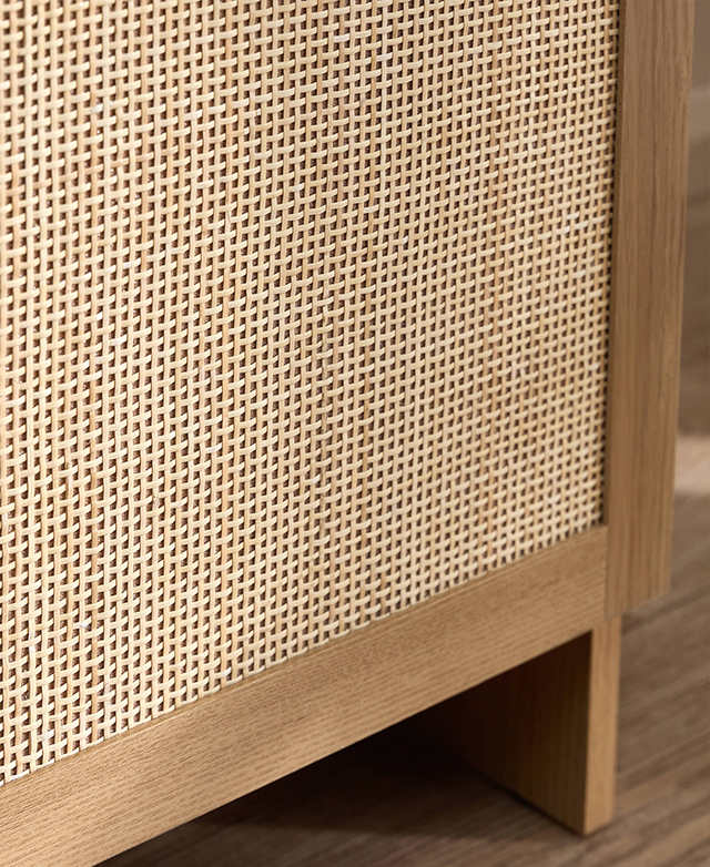 A close view highlights the rattan weave on the cupboard doors.